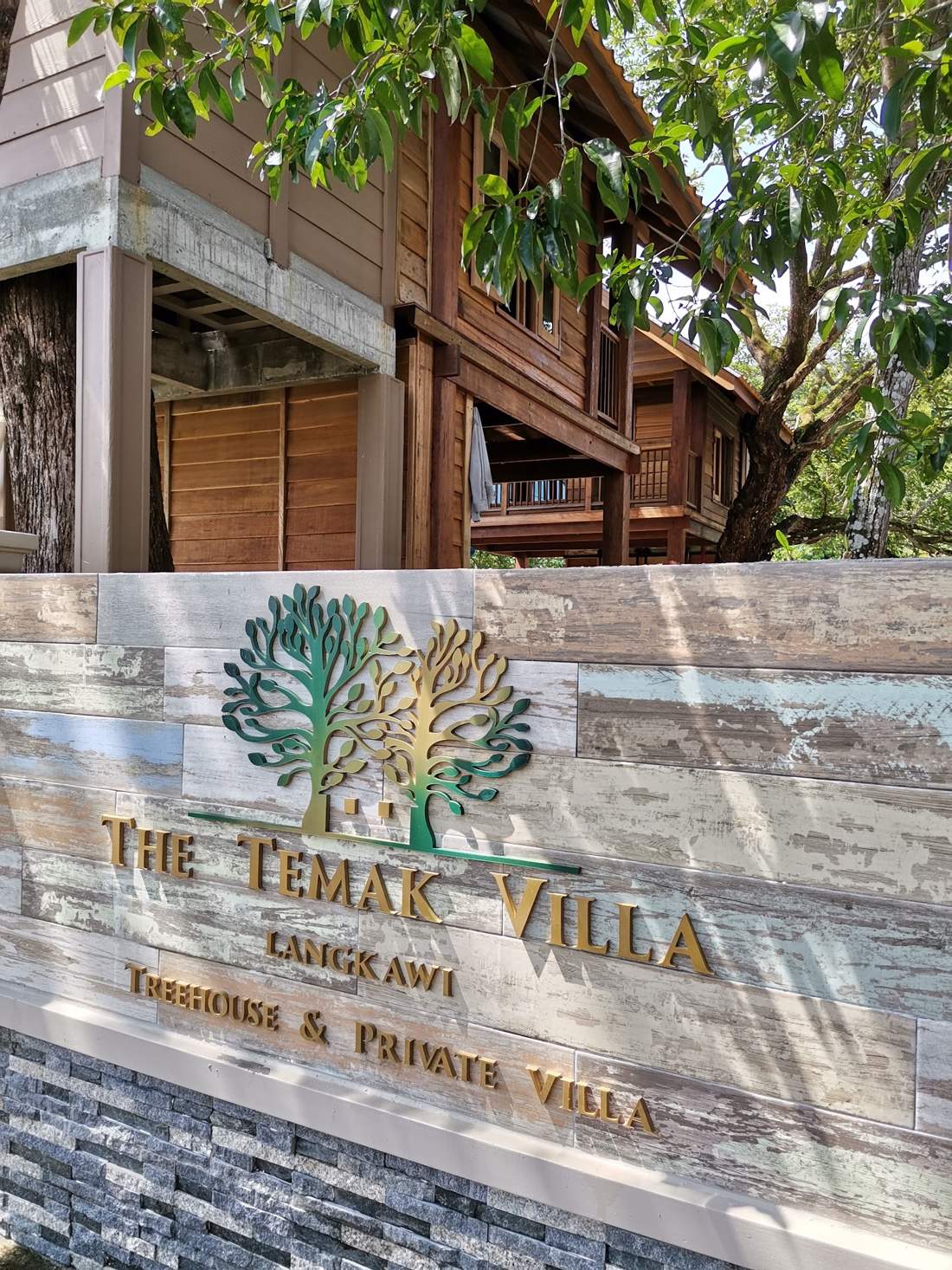 The Temak Villa sign wall with the treehouse behind